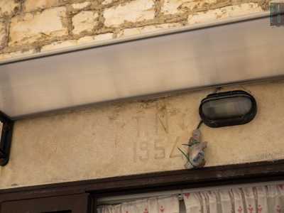 ...un altro poco pi� avanti che sopra la porta reca ancora l�iscrizione �1954�...